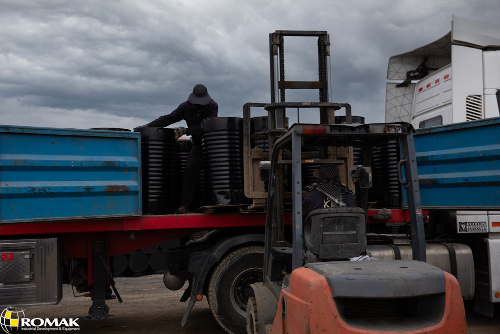 1 A close-up view of high-quality Iran bitumen in solid form, neatly stacked in large drums, ready for export and industrial use in construction projects.